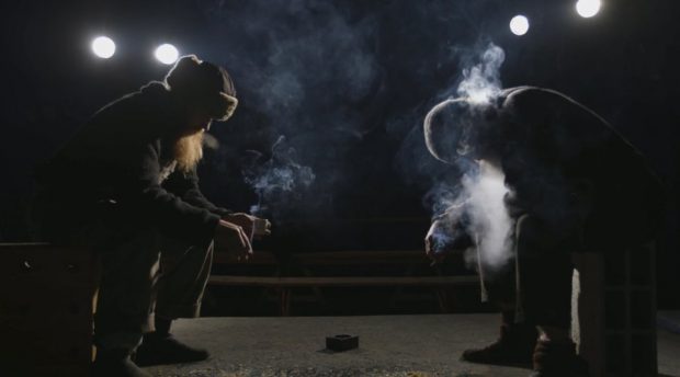 Image extraite de la bande-annonce de Bonnet d'Hômme de Frédéric Barrette - on y voit le profil de deux hommes barbus assis dans le noir en train de fumer des cigarettes