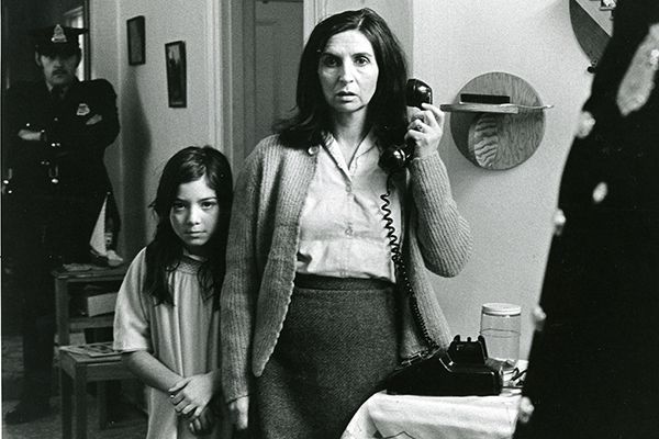 Sur la photo, la comédienne Hélène Loiselle est arrêtée par deux policiers, sa petite fille blottie contre elle dans le film Les Ordres (Collection Cinémathèque québécoise)