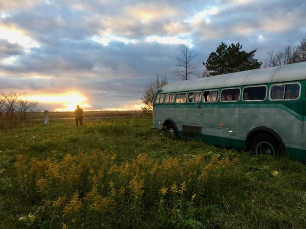 Wilcox et son autobus vert face au soleil couchant dans la campagne québécoise (extrait du film de Denis Côté)