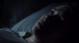 Lee Marshall dans Bleed With Me de Amelia Moses (dans le noir, gros plan sur le visage de la jeune femme, allongée et pensive)