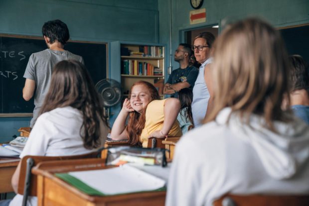 Alexane Jamieson sur le tournage de Jeune Juliette (la jeune fille est dans une salle de classe et regarde la caméra en souriant)